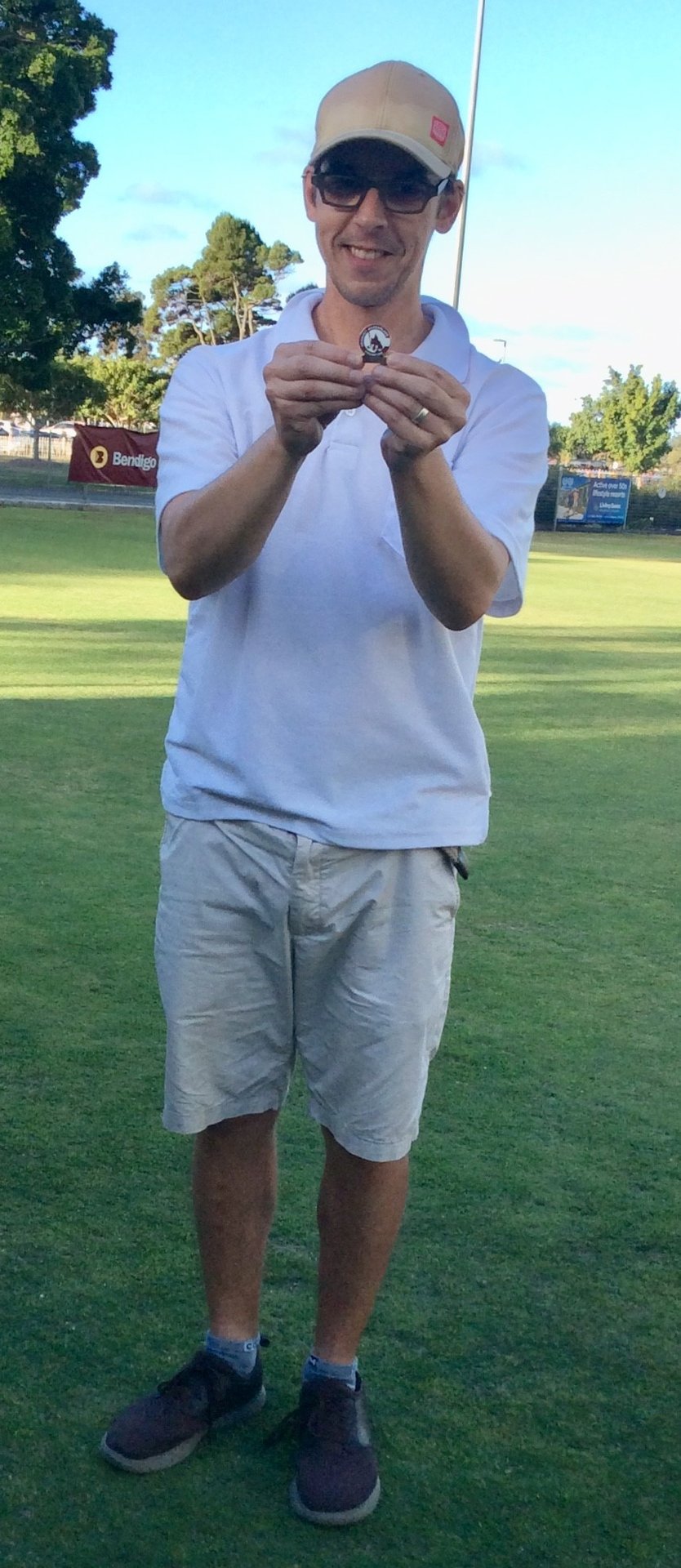Player holds a croquet ball on the club lawn on a sunny day