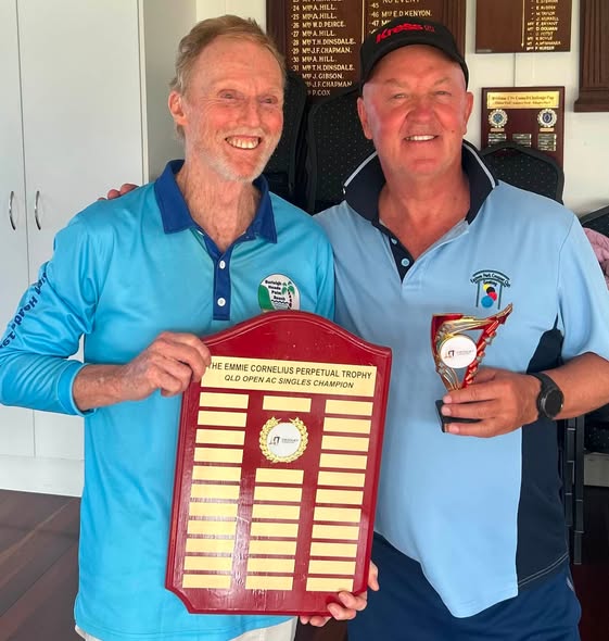 Two men pose with a trophy and plaque for the Emmie Cornelius Perpetual Trophy, Old Open AC Singles Champion, at a croquet event